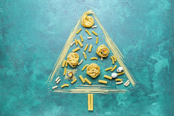 Christmas tree shape made of uncooked pasta on color background