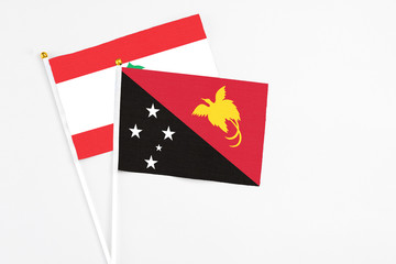 Papua New Guinea and Lebanon stick flags on white background. High quality fabric, miniature national flag. Peaceful global concept.White floor for copy space.
