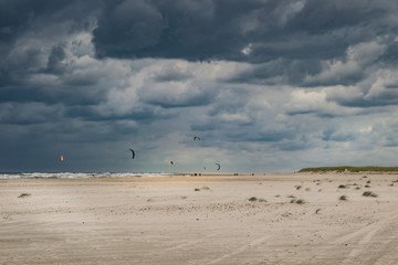 sand dunes and blue sky with kitesurfers
