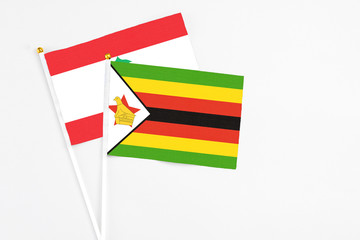 Zimbabwe and Lebanon stick flags on white background. High quality fabric, miniature national flag. Peaceful global concept.White floor for copy space.