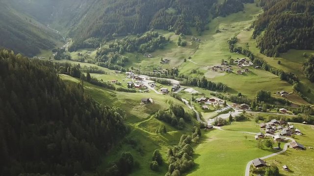 Aerial tracking shot of village in a mountain valley in France
