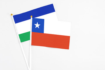 Chile and Lesotho stick flags on white background. High quality fabric, miniature national flag. Peaceful global concept.White floor for copy space.