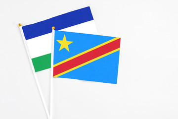 Congo and Lesotho stick flags on white background. High quality fabric, miniature national flag. Peaceful global concept.White floor for copy space.