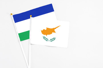Cyprus and Lesotho stick flags on white background. High quality fabric, miniature national flag. Peaceful global concept.White floor for copy space.