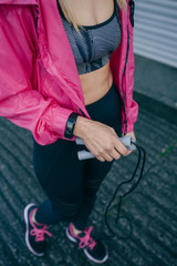Unrecognizable young woman with sportswear holding jump rope outdoors © David Pereiras