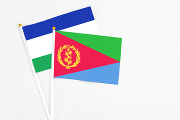 Eritrea and Lesotho stick flags on white background. High quality fabric, miniature national flag. Peaceful global concept.White floor for copy space.