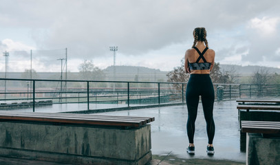 Young sportswoman posing on her back watching the rain outdoors