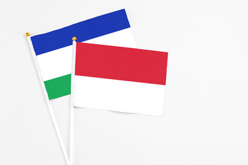 Indonesia and Lesotho stick flags on white background. High quality fabric, miniature national flag. Peaceful global concept.White floor for copy space.