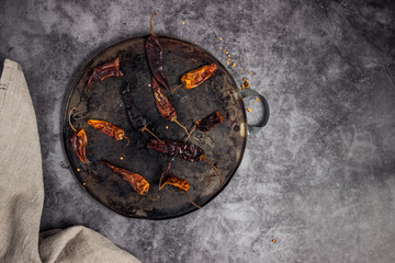 Dry chillis in a comal or hotplate for being roasted with a white fabric aside