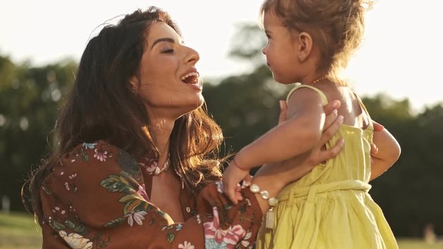 Happy indian woman playing and enjoys the moment with her smiling child girl outdoors