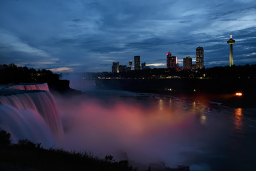 Fototapeta na wymiar Light showcase lighting cascades of water Niagara Falls. Illuminated night view of Niagara Falls. USA.
