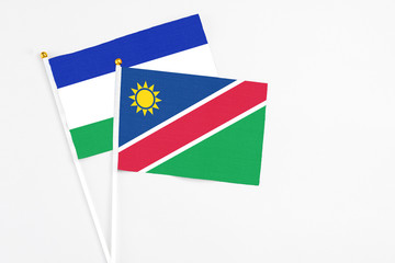 Namibia and Lesotho stick flags on white background. High quality fabric, miniature national flag. Peaceful global concept.White floor for copy space.