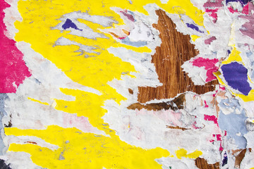 Collage of colourful torn magazine paper glued on rough surface. Grungy street billboard with...