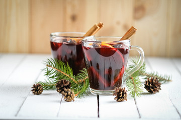 Mulled wine in glass glasses with apples, orange, cinnamon and star anise. Hot christmas drink on...