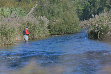 Obraz na płótnie Canvas fly fisherman in autumn and fast river