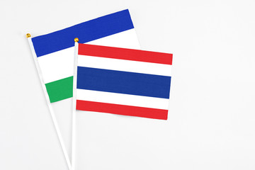 Thailand and Lesotho stick flags on white background. High quality fabric, miniature national flag. Peaceful global concept.White floor for copy space.
