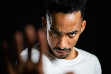 No, never, handsome african american man disliking and rejecting gesture by stop sign. Portrait of young successful confident guy isolated on black
