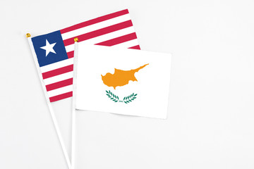 Cyprus and Liberia stick flags on white background. High quality fabric, miniature national flag. Peaceful global concept.White floor for copy space.
