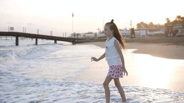 Little girl playing on the beach in summer