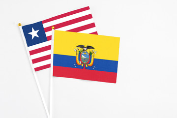 Ecuador and Liberia stick flags on white background. High quality fabric, miniature national flag. Peaceful global concept.White floor for copy space.