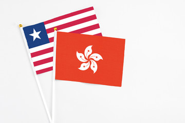 Hong Kong and Liberia stick flags on white background. High quality fabric, miniature national flag. Peaceful global concept.White floor for copy space.