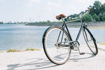 bicycle near blue river in summer in sunshine