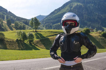 Close up portrait of a girl in full body protection, turtle armor, knee pads and helmet, on a background of green mountains, summer sunny day, rady to ride for adventure. copy space