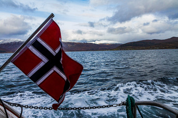 Norway flag in a boat traveling a fjord