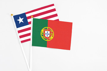 Portugal and Liberia stick flags on white background. High quality fabric, miniature national flag. Peaceful global concept.White floor for copy space.