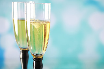 Background with tall glasses for sparkling wines. Champagne and spray in glass glasses. Celebratory drink with reflection.
