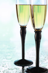 Background with tall glasses for sparkling wines. Champagne and spray in glass glasses. Celebratory drink with reflection.