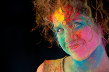 Woman with Holifest paint splattered on her happy face. 