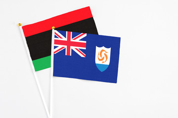 Fototapeta premium Anguilla and Libya stick flags on white background. High quality fabric, miniature national flag. Peaceful global concept.White floor for copy space.