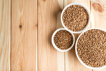 Buckwheat in a light bowl on a rustic background top view copy space.