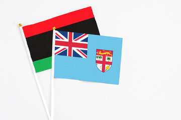 Fiji and Libya stick flags on white background. High quality fabric, miniature national flag....