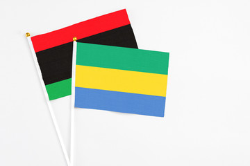 Gabon and Libya stick flags on white background. High quality fabric, miniature national flag....