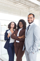 Happy confident professional team posing for camera in contemporary hallway. Business man and women...