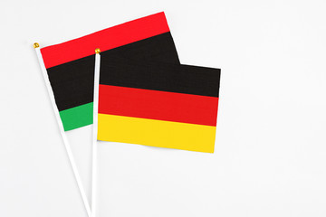 Germany and Libya stick flags on white background. High quality fabric, miniature national flag. Peaceful global concept.White floor for copy space.