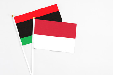 Indonesia and Libya stick flags on white background. High quality fabric, miniature national flag. Peaceful global concept.White floor for copy space.