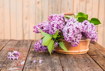 Bouquet of lilac flowers on wooden background - selective focus. Vintage floral background