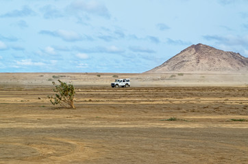 Crossover car driving over the arid landscape near Buracona on the island Sal, Cape Verde