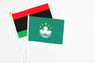Macao and Libya stick flags on white background. High quality fabric, miniature national flag. Peaceful global concept.White floor for copy space.