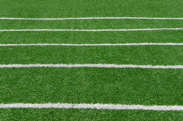 Obraz premium white line as running lane on the green grass