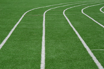 Obraz premium white line as running lane on the green grass