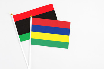 Mauritius and Libya stick flags on white background. High quality fabric, miniature national flag. Peaceful global concept.White floor for copy space.