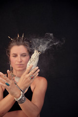 Woman shaman in ceremony practice with smudge stick, 