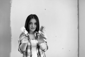 Obraz premium The builder makes repairs in the apartment. Finishing works on plastering and painting of walls. Masters work with paint drill and electricity.