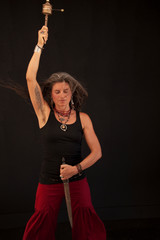 Shamanic priestess with prayer wheel and a symbolic dagger cutting through negative energy. 