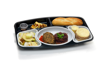 Plateau repas noir avec pain plat et desert isolé sur fond blanc