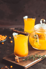 Autumn or winter sea buckthorn drink. Sea Buckthorn tea, selective focus. Still life, food and drink, seasonal and holidays concept. Autumn hot beverage in a glass